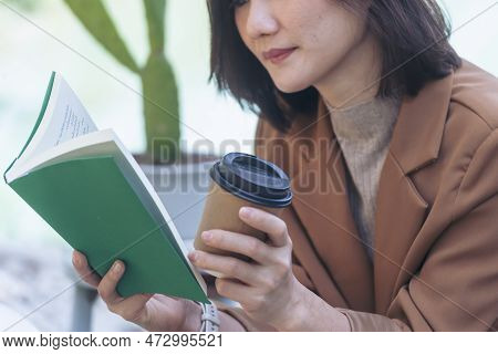 Happy Asian Woman Reading Book Outdoor In Green Park Nature. Reading Book Magazine Relaxation Woman.