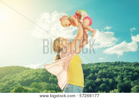 Happy Family. Mother Throws Up Baby In The Sky