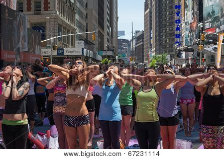 Thousands of New Yorkers are make the first day of summer by practicing yoga in Times Square