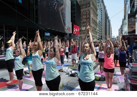Thousands of New Yorkers are make the first day of summer by practicing yoga in Times Square