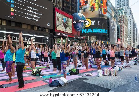 Thousands of New Yorkers are make the first day of summer by practicing yoga in Times Square