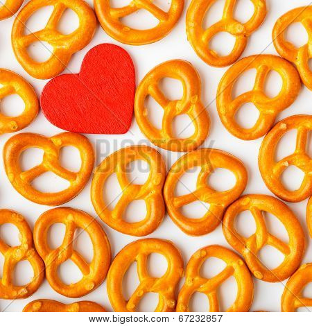Valentine's Day Background Pretzels Pattern And Red Heart.