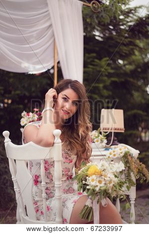 Beautiful Woman Sitting On A White Vintage Chair, Holding A Bouquet, In A Shabby Chic, Vintage Decor