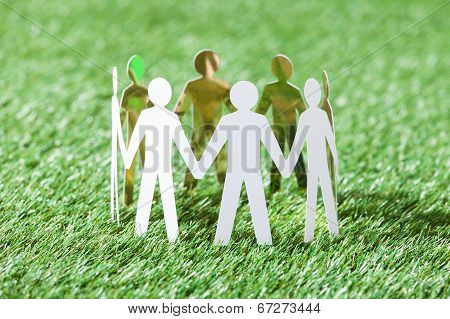 Team Of Paper People On Grassy Field