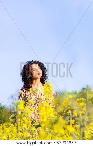 happy carefree young beautiful girl basking in the sun in the field