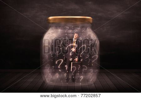 Businessman locked into a jar with question marks concept on background