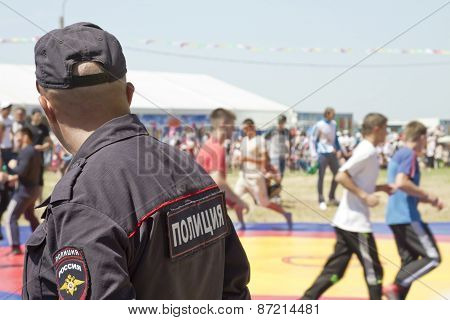 policeman in a baseball cap looks thoughtfully into the distance