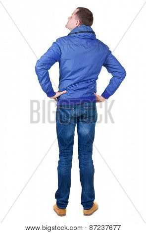 Back view of handsome man in brown windcheater looking up.   Standing young guy in jeans. Rear view people collection.  backside view of person.  Isolated over white background.