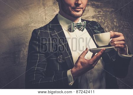 Sharp dressed fashionist with cup of coffee