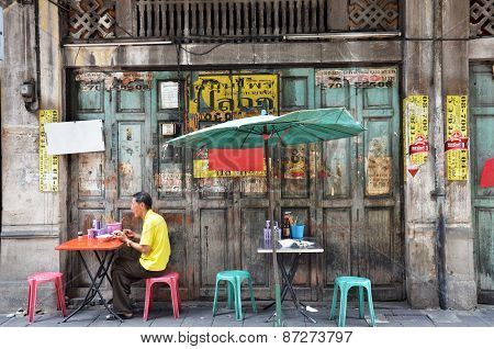 Unidentified Man Eats On A Street In Chinatown District, Bangkok, Thailand