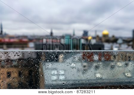 Roofs And Spiers Of The City Behind A Glass Partition In The Rain