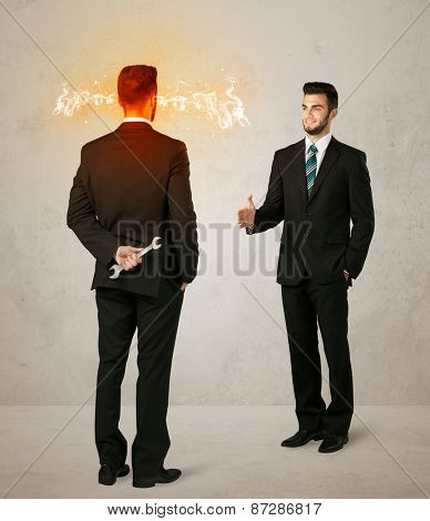 Angry businessman hiding a weapon behind his back 