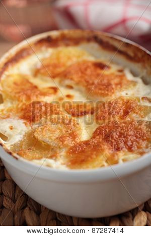 Potatoes a la dauphinoise in a baking dish. Selective focus on the potato crust