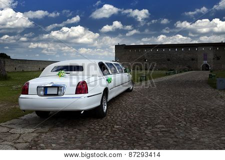 White wedding limousine in the yard of fortress Narva Estonia - a traditional place of wedding cerem