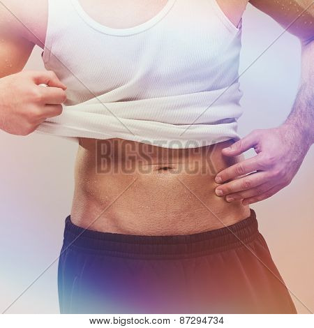 Fit handsome man in white shirt showing abdominal muscles