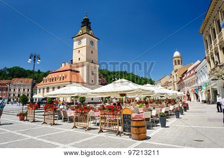 Brasov, Transylvania, Romania, 6th July 2015: Brasov Council Square is historical center of city, people walkinng and sitting at outdoor terraces and restaurants.