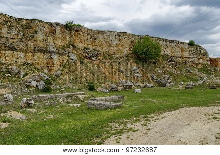 General view toward crag of sedimentary rock in the field