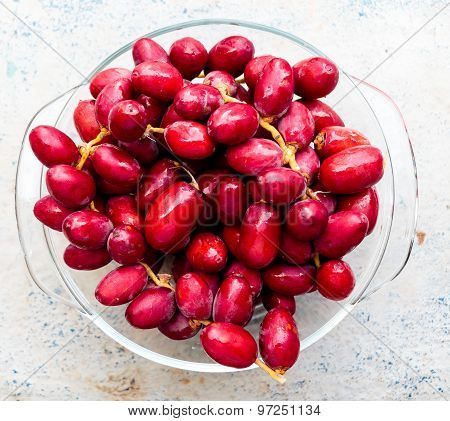 Fresh raw reddish pink date palm fruits taken out from refrigerator and kept on a bowl