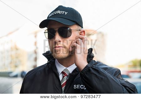 Security Guard Listening To Earpiece