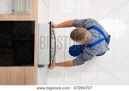 Man Repairing Kitchen Oven