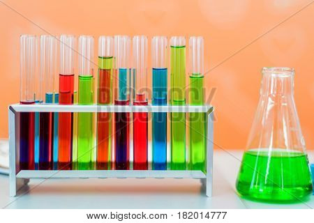 Laboratory expreriment with test-tubes with colored chemical reagents, retorts and flasks