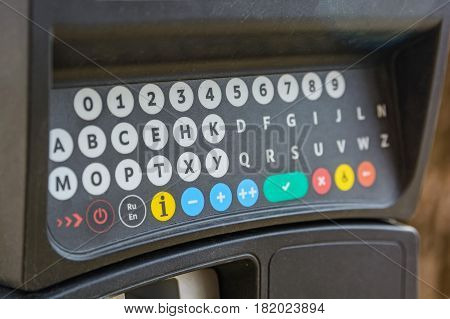 Close up of parking meter with colorful buttons in the street