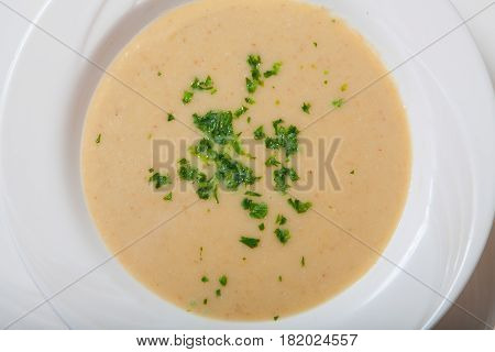 Creamy Vegetables Soup With Fresh Herbs In A White Bowl