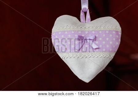 Closeup of heart made of white and violet cloth valentine souvenir