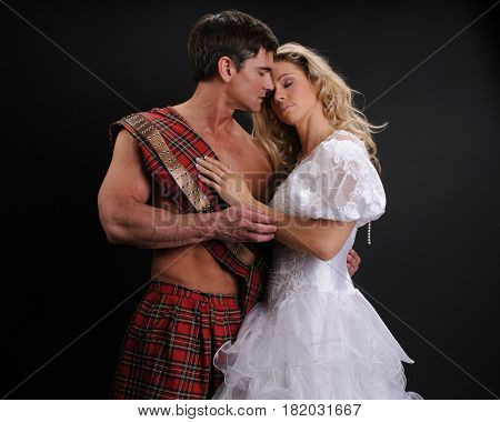 The handsome highlander is hugging his princess.