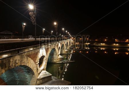 Pont Neuf beautifully illuminated on dark night across Garrone River Toulouse France.