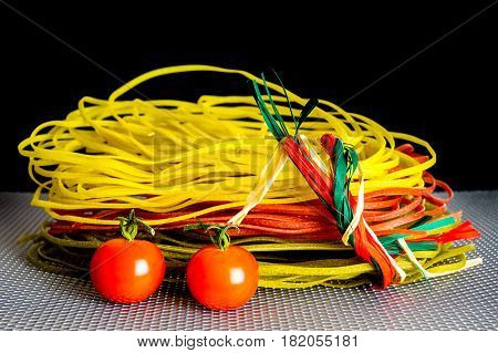 Tasty color pasta with two red tomatoes and grid background