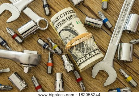 Hand tools and money on wooden table