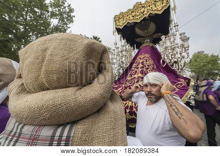 Linares, SPAIN - April 14: Group of costaleros name given to those who carry thrones, takes a rest during a religious procession in the streets of Linares, procession of holy week, Andalucia, Spain