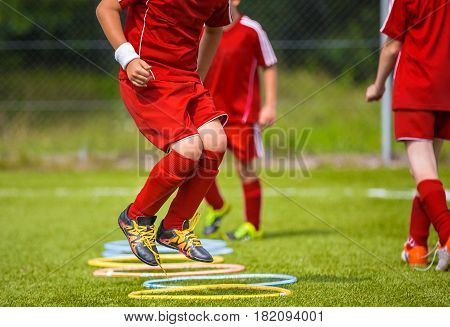 Young Soccer Player Practicing on the Pitch. Soccer Football Equpment. Dynamic Jumping Football Training