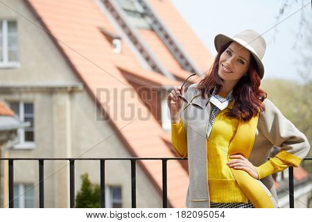 Close-up Fashion woman portrait of young pretty trendy girl posing at the city in Europe,summer street fashion,holding retro fedora hat popular until the 60s.laughing and smiling portrait.trendy