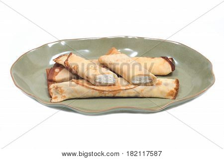 Delicious cheese blintz on green plate isolated on white background