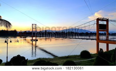Tak Thailand Nov05 2015 : 200 year Rattanakosin Sompoch bridge (hanging bridge) across the ping River during colorful twilight sky. Tak province Thailand