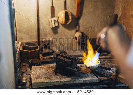Jeweler melting gold and making jewelry in shop