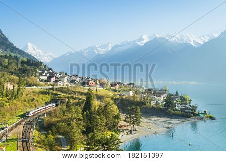 View of the small town in the Alps mountains. Railway along Lake Lucerne. Canton of Uri.