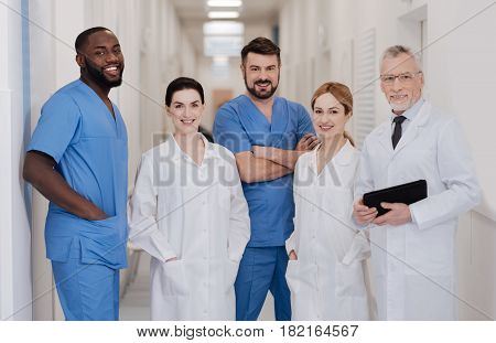 Studying new together. Smiling professional positive doctors enjoying job responsibilities in the hospital and working in one team while expressing positivity