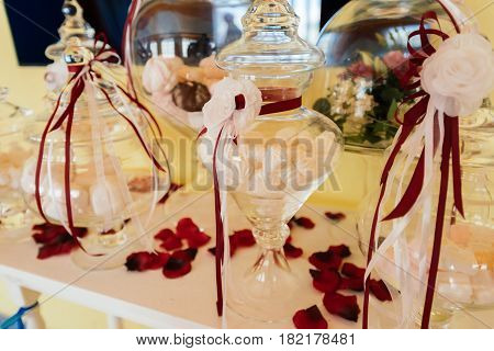 Holiday candy bar. Zephyr in a glass vase decorated with flowers and ribbons on the dining table