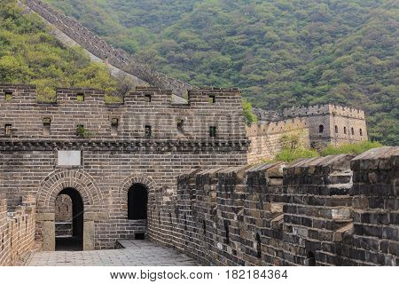 Entrance to watchtower of the Great Wall of China on the Mutianyu section with scenic mountain slope on the background