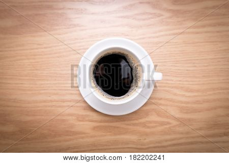 Isolated cup of espresso. Hot coffee in white cup on wooden table.