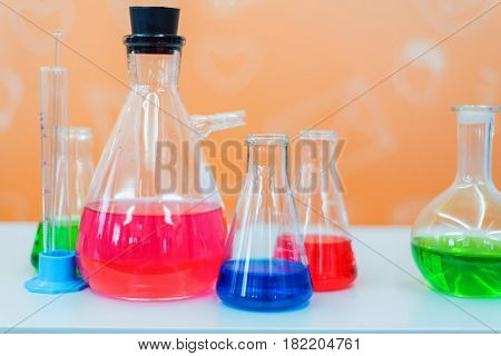 Laboratory expreriment with test-tubes with colored chemical reagents, retorts and flasks