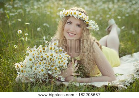 Cute blond lady woman with curly hairs on camomile field