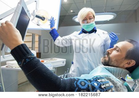 Dental doctor and patient. Man looking at the screen. Diagnostics and urgent treatment.