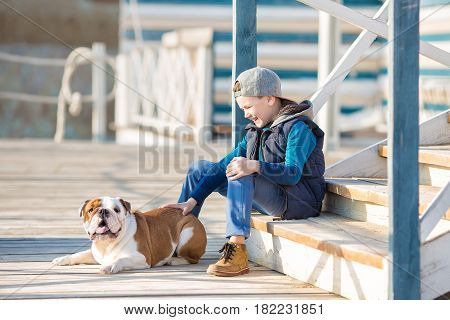 Nice looking handsome boy on beach with english bulldog