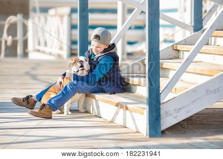 Nice looking handsome boy on beach with english bulldog