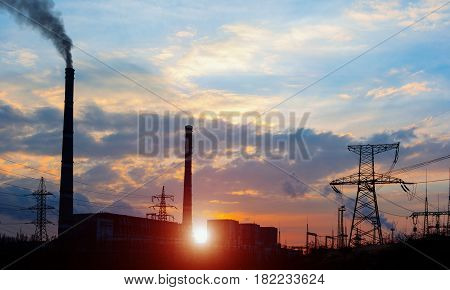 distribution electric substation with power lines and transformers at sunset