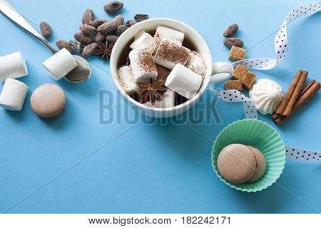 cocoa with marshmallows and Macarons on a blue background top view